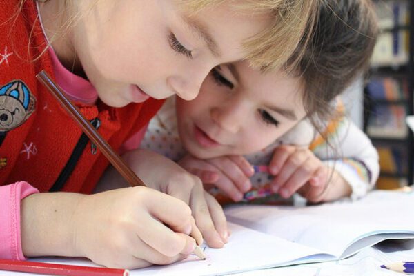 Bild zeigt zwei Kinder die etwas aufschreiben