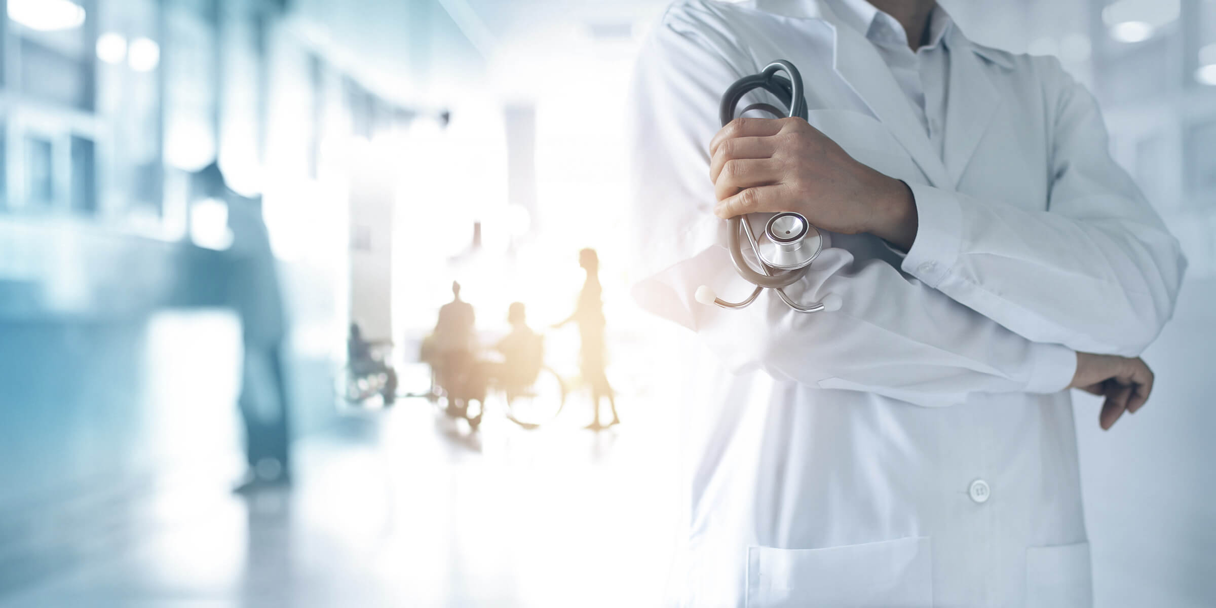 Bild zeigt einen Arzt mit Stethoskop in der Hand und Patienten im Hintergrund