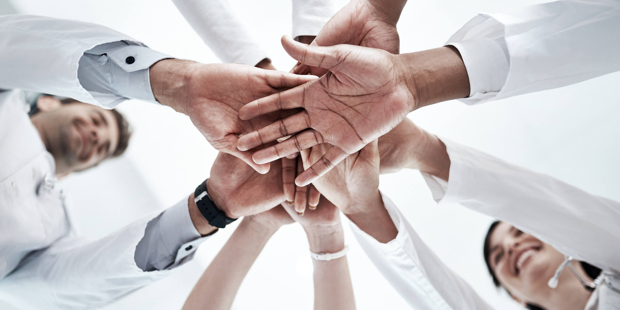 Bild zeigt viele Hände übereinandergestappelt, Sicht von unten.